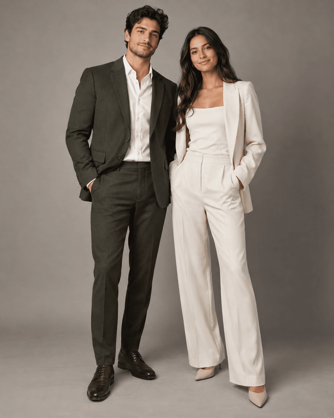 AI-generated two fictional adults in simple formal outfits against a warm gray studio backdrop, composed full-length portrait.