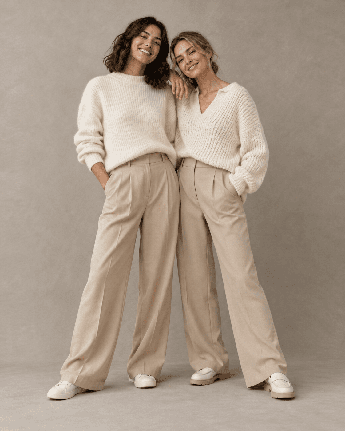 AI-generated two fictional adults together in ivory knitwear and sand-colored tailored separates, simple warm-gray studio, full-length.
