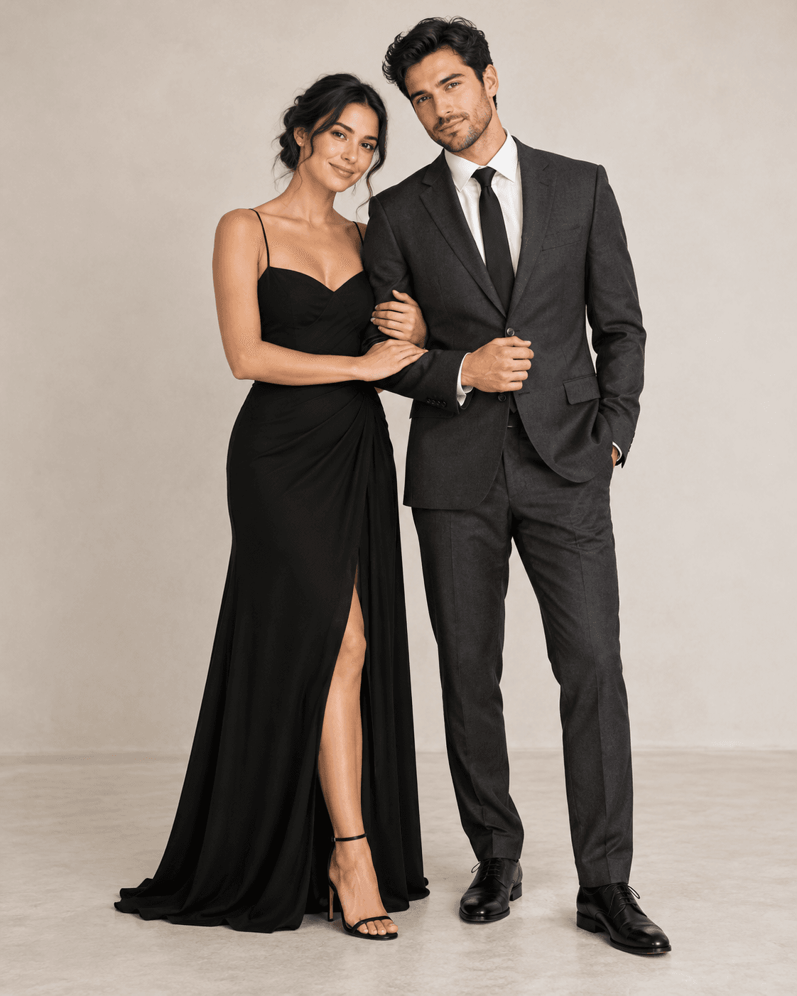 AI-generated fictional adult couple in a pale studio, one in a simple black long dress, partner in charcoal tailoring, soft even light.