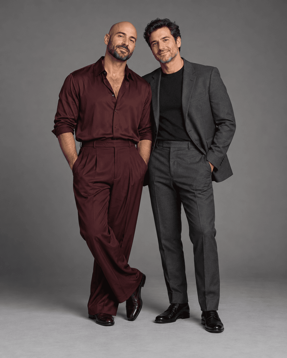 AI-generated full-length studio concept of two fictional adults: Person A wears dark burgundy fluid separates; Person B wears a charcoal structured jacket and trousers.