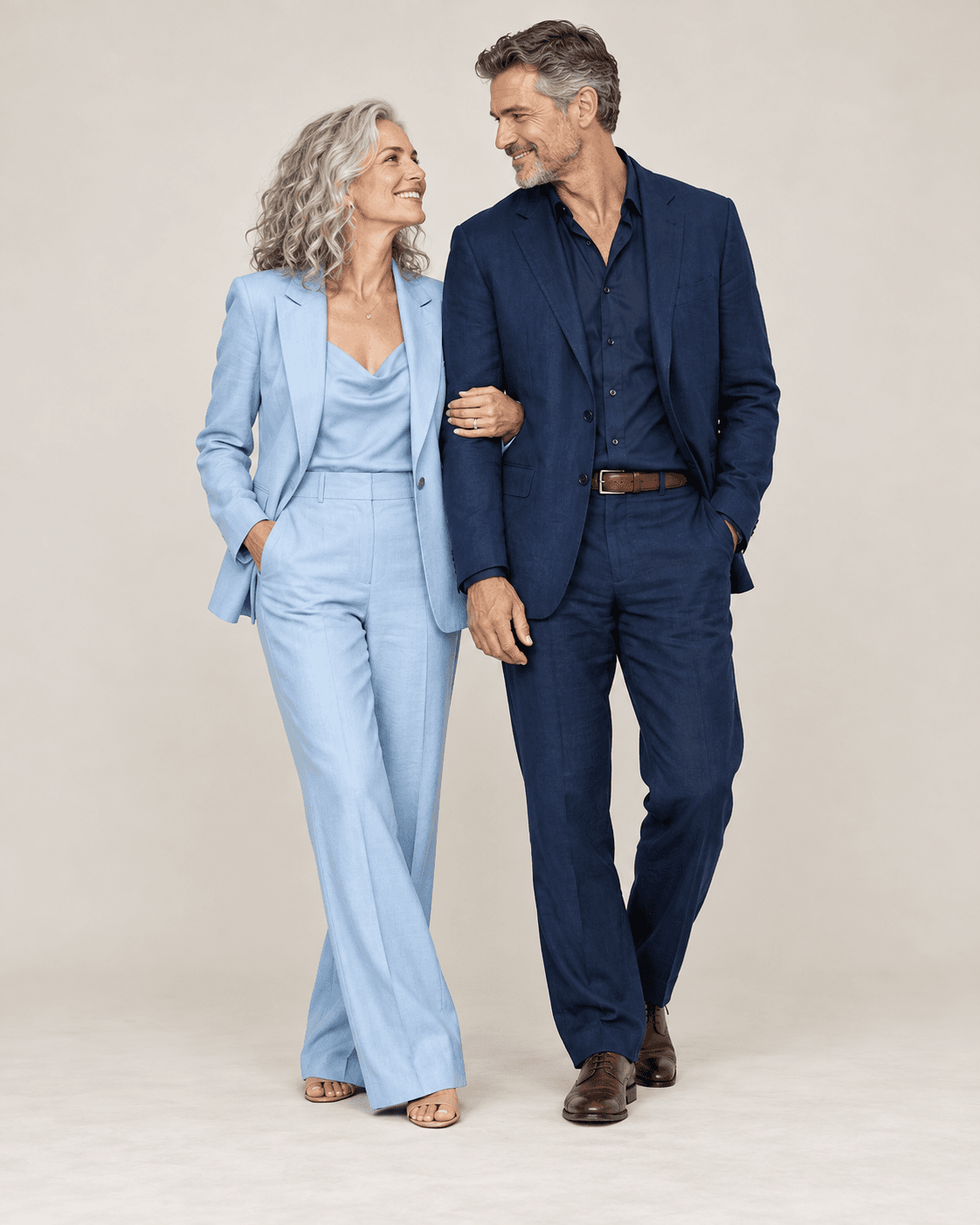AI-generated full-length studio concept of two fictional adults: one wears a pale-blue tailored suit, and the other wears a deep-navy jacket, shirt and trousers.