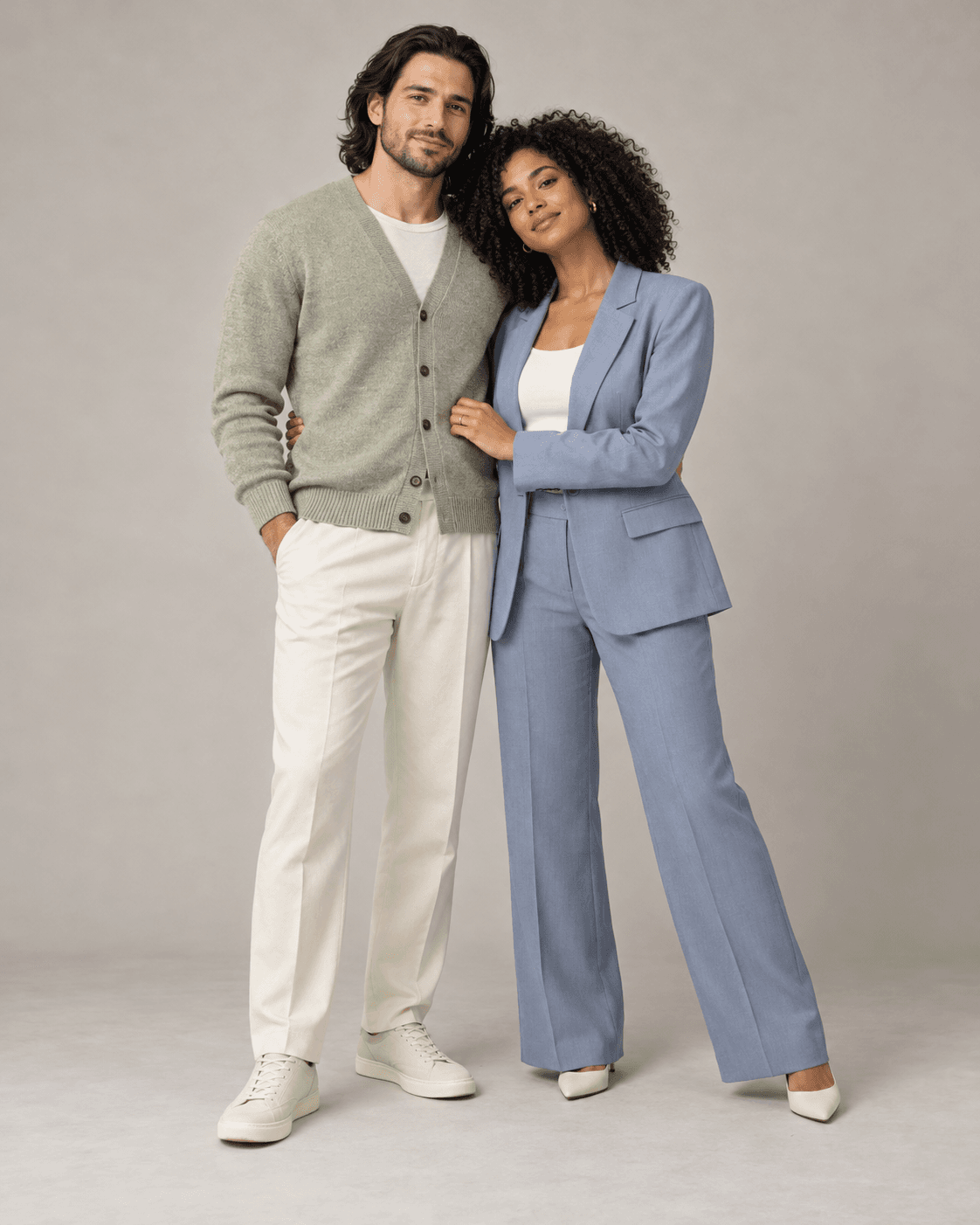 AI-generated full-length studio concept of two fictional adults: Person A wears a pale sage cardigan and cream trousers; Person B wears muted blue soft tailoring.