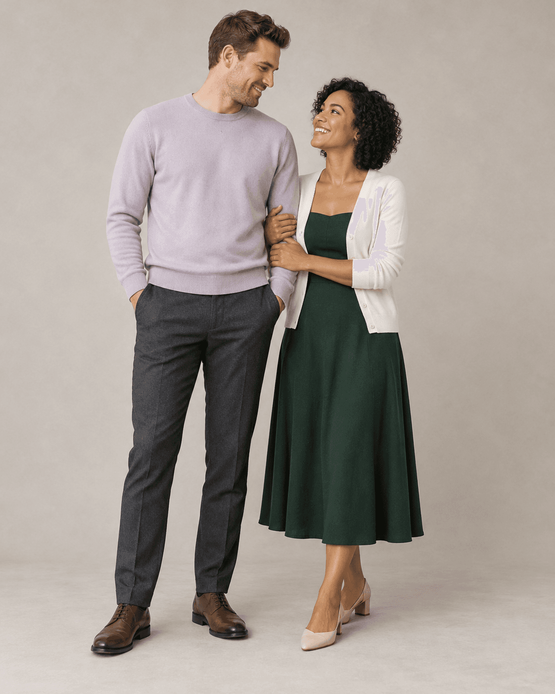 AI-generated full-length studio concept of two fictional adults: Person A wears a pale-lilac knit and charcoal trousers; Person B wears a forest-green dress with a cream cardigan.